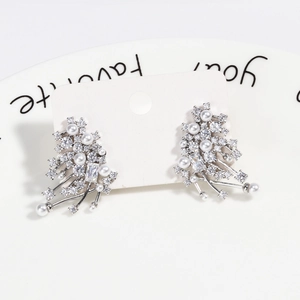 Detail of silver pearl stud earrings with zircon in a radiant fountain design