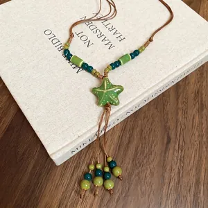 Handmade ceramic star pendant necklace with green beads and brown wax rope tassels
