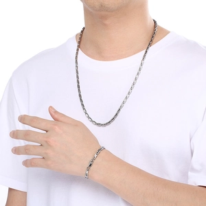 Close-up of minimalist silver stainless steel U-link chain necklace and bracelet set on model