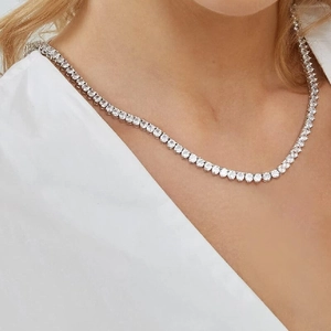 Silver 3-prong tennis necklace with round cubic zirconia worn by a female model