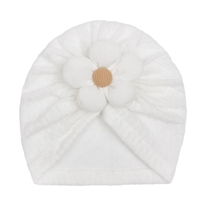 Detailed view of the soft knitted white baby turban with a large 3D flower decorative knot