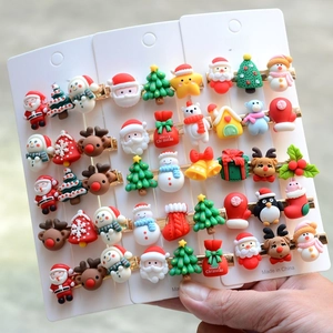 Close-up of colorful resin Santa and reindeer hair clips on a white display card
