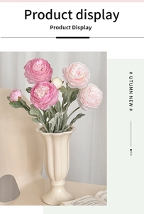 Macro detail of artificial pink ranunculus flowers in a stylish wavy ceramic vase