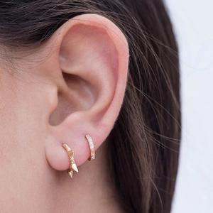 Set di orecchini a cerchio punk dorati con punte e cristalli pavé sull'orecchio