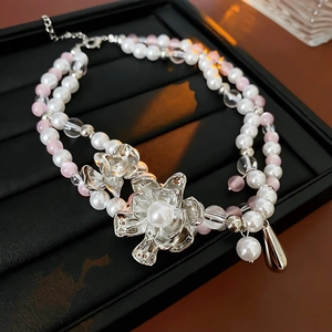 Close-up of double-layer beaded necklace with silver flowers and water-drop pendant