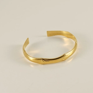 Detail of 18K gold plated stainless steel open bangle with bamboo texture and leaf patterns
