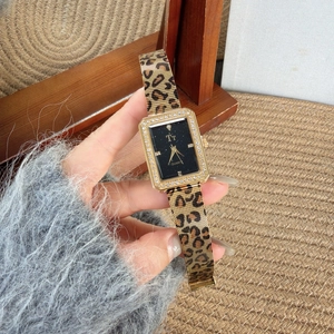 Macro detail of gold rectangle quartz watch with diamond bezel and leopard print band