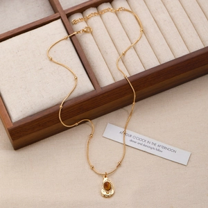 Macro shot of tiger eye stone pendant on gold snake chain resting on wooden box