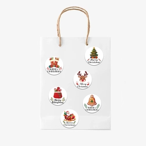 Close-up of colorful cartoon Christmas stickers applied on a white gift bag detail