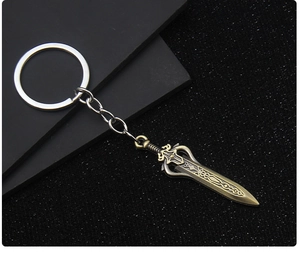 Dettaglio portachiavi a forma di spada in metallo bronzo vintage con incisioni fantasy