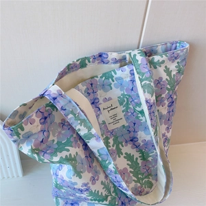 Gros plan sur un sac cabas en toile à fleurs avec doublure et poignées tissées