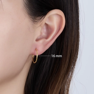 Detail view of 16mm gold hoop earrings in 925 silver shown on model ear for scale