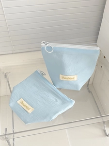 Detail of light blue waterproof nylon storage bags with white zippers and round pullers