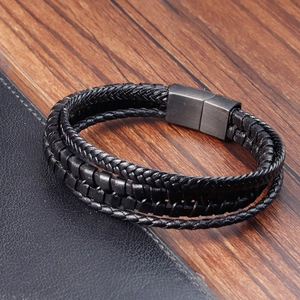 Detail of woven black leather bracelet layers with matte grey magnetic metal clasp