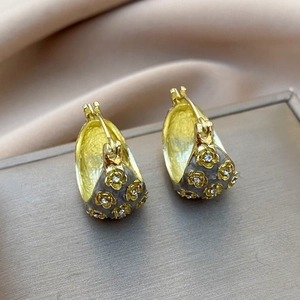 Macro detail of retro floral earrings with gold plating and cubic zirconia inlay