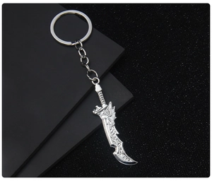 Detail of silver metal sword keychain pendant on a professional black textured surface