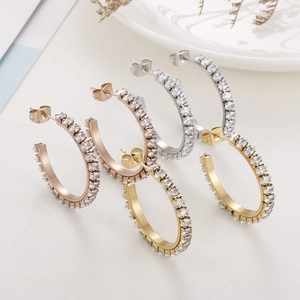 Close-up of hoop earrings featuring marquise-cut white zircons in gold and silver finish