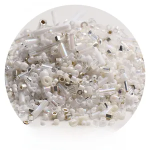 Macro detail of mixed white and iridescent glass beads in round and tube shapes