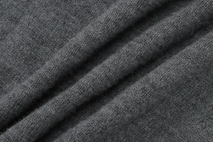 Vue macro détaillée du tissu tricoté gris foncé montrant la texture fine des fibres douces