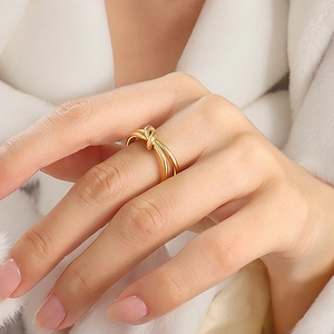 Detailed view of a multi-layer gold knot ring on model with soft white background