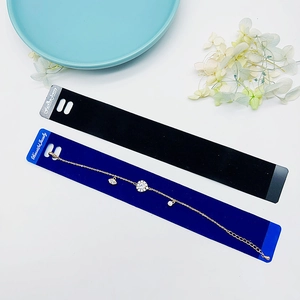 Bracciale dorato con ciondoli occhio e sole su un cartoncino in velluto blu scuro