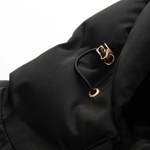 Detailed close-up of adjustable gold drawstring toggle on black padded jacket