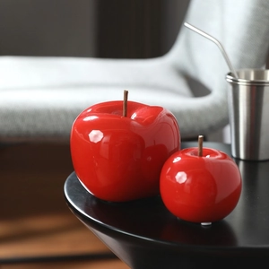 Décoration moderne de pommes en céramique rouge sur une table noire élégante
