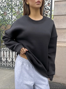 Detail of crewneck sweatshirt ribbing and elastic waistband on grey joggers
