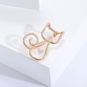 Nahaufnahme einer minimalistischen goldenen Katzenbrosche auf weißem Hintergrund