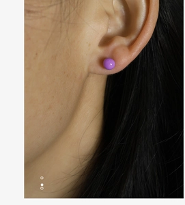 Close-up of minimalist purple ball stud earring worn on ear for size reference
