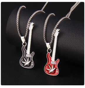 Détail de colliers guitare rouge et noir avec pendentifs feuille sur fond en cuir noir