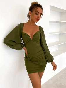 Detalle de vestido verde oliva con escote en V, mangas abullonadas y diseño fruncido