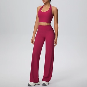 Detailed view of halter neck sports bra and high-waisted wide leg yoga pants in magenta