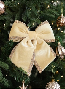 Detailed close-up of velvet Christmas tree bow in champagne gold with glitter edges