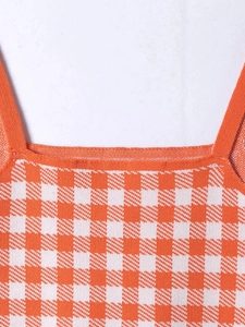 Detailed macro view of orange and white gingham knit fabric with clean seam stitching