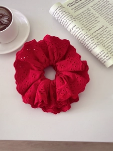 Detailed flat lay of a large red cotton eyelet lace scrunchie with floral embroidery