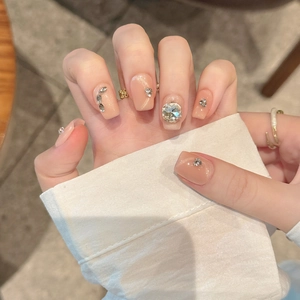 Faux ongles faits main en amande avec effet œil de chat pêche et strass brillants