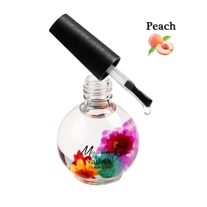 Macro-opname van 15ml perzik nagelriemolie met droogbloemen en zwarte borstel applicator