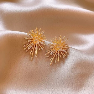 Detailed macro view of 18k gold plated starburst earrings with zirconia and champagne silk