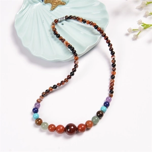 Macro detail of natural multi-color stone beaded necklace with gradient size beads