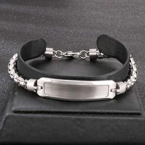 Macro shot of silver metal nameplate and black silicone strap on a hip hop bracelet