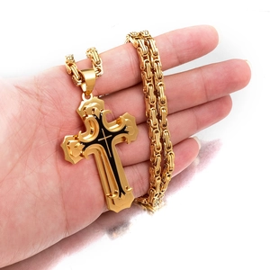 Macro shot of gold stainless steel cross pendant necklace with black oil finish details
