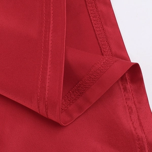 Detailed macro view of the smooth red satin fabric texture and premium hem stitching
