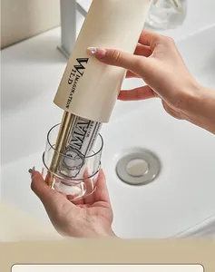 Portable cream wash cup set holding a toothbrush and toothpaste in a bathroom setting