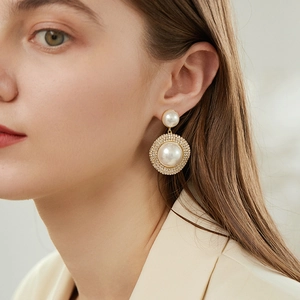 Detail of luxury pearl drop earrings with sparkling rhinestones in a gold finish