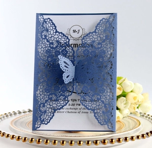 Detail of laser-cut lace wedding invitation with a 3D butterfly on a blue cover