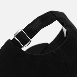 Detail of adjustable metal buckle and stitching on black cotton baseball cap back