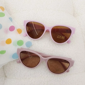 Detailed top view of cherry and lotus pink cat-eye sunglasses with UV400 protection labels