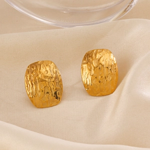 Minimalist gold geometric oval earrings with vintage hammered metal texture on silk