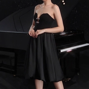 Detail of elegant black tube dress featuring silver rhinestone bows and sweetheart neckline